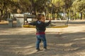 Rear view boy having fun with the swing at the playground Royalty Free Stock Photo