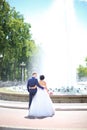 Rear view.bride groom standing in front of the fountain