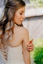 rear view. bride with long wavy hair in the garden. Wedding make-up.