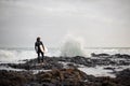 Rear view brunette boy standing with a surf in his hands on the shore looking on the wave Royalty Free Stock Photo