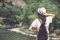 Rear view of brunette girl in park in straw hat.