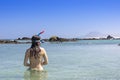 Rear View of brunette woman wearing snorkel and mask looking to