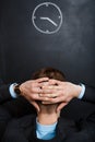 Rear view of business man looking at clock. hands behind his hea Royalty Free Stock Photo
