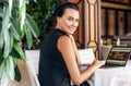 Rear view of business woman smiling and working with laptop in a cafe. Portrait of succesful young female reading news on laptop Royalty Free Stock Photo