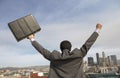 Rear View Of Businessman With Arms Out In Front Of Buildings Royalty Free Stock Photo