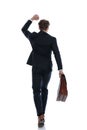 Rear view businessman celebrating and holding briefcase Royalty Free Stock Photo