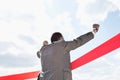 Rear view of businessman crossing finish line against sky Royalty Free Stock Photo