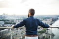 A rear view of businessman standing against London view panorama at sunset. Royalty Free Stock Photo