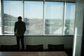 Rear view of businessman standing by window in meeting room Royalty Free Stock Photo