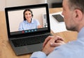 Rear View Of A Businessman Videoconferencing With Female Colleague Via Laptop Computer