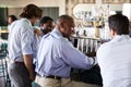 Rear View Of Businessmen Meeting For After Works Drinks In Bar