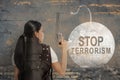 Rear view of a businesswoman holding gun with a stop terrorism sign Royalty Free Stock Photo