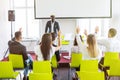 Rear view of businesspeople raising hand during seminar of afro american business coach in conference hall Royalty Free Stock Photo