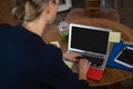 Rear view of businesswoman using laptop in office Royalty Free Stock Photo