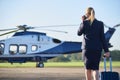 Rear View Of Businesswoman Walking Towards Helicopter Whilst Talking On Mobile Phone Royalty Free Stock Photo