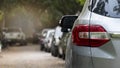 Rear view of a car in a residential parking lot. Visible taillights of a gray car and blurred of mirror wing. Royalty Free Stock Photo