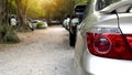 Rear view of a car in a residential parking lot. Visible taillights of silver car and blurred of mirror wing. Royalty Free Stock Photo