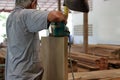 Rear view of carpenter using belt sander in carpentry workshop Royalty Free Stock Photo