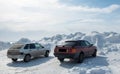 Rear view of cars standing by a huge snowdrift formed after clearing the roads from snow Royalty Free Stock Photo