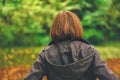 Rear view of casual female walking in autumn park