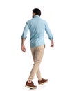 rear view of casual man wearing blue denim shirt walking and looking to side Royalty Free Stock Photo