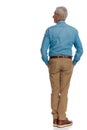 Rear view of casual old man with blue denim shirt and chino pants Royalty Free Stock Photo