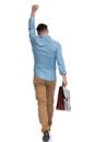 Rear view of a celebrating casual man holding briefcase Royalty Free Stock Photo