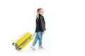 Rear view of child carrying yellow wheel suitcase