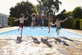 Rear View Of Children Jumping Into Outdoor Swimming Pool Royalty Free Stock Photo