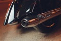 Rear view of classical motorcycle pair of exhaust chrome pipes selective focus.