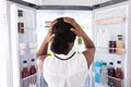 Confused Woman Looking In Open Refrigerator Royalty Free Stock Photo