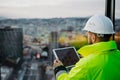 Rear view of construction site manager using digital tablet to inspect building progress. Royalty Free Stock Photo