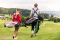 Rear view of couple carrying golf bag Royalty Free Stock Photo