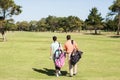 Rear view of couple carrying golf bags Royalty Free Stock Photo