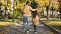 Rear view of couple in love walking in autumn park