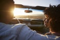 Rear View Of Couple On Road Trip Driving Classic Convertible Car Towards Sunset Royalty Free Stock Photo