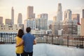 Rear View Of Couple On Rooftop Terrace Looking Out Over City Skyline At Sunset Royalty Free Stock Photo
