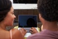 Rear View Of Couple Sitting On Sofa Using Laptop Royalty Free Stock Photo