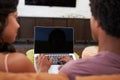Rear View Of Couple Sitting On Sofa Using Laptop Royalty Free Stock Photo