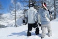 Rear view of couple walking away from camera, holding winter sport equipments. Conceptual image Royalty Free Stock Photo