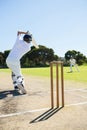 Rear view of cricket player batting while playing on field Royalty Free Stock Photo