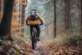 Rear view of a cyclist riding a mountain bike along a trail in a picturesque autumn forest. Extreme sports and enduro Royalty Free Stock Photo