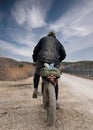 Rear view of cyclist riding on mud dirt road and completely muddy clothes Royalty Free Stock Photo