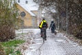 Rear view of a cyclist riding on a paved sidewalk during a snowfall, Riga, Latvia