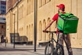 Rear view of delivery man standing with bicycle and thermo bag on the sunny street Royalty Free Stock Photo