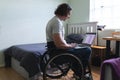 Rear view of disabled man sitting on wheelchair using laptop with copy space on couch at home Royalty Free Stock Photo