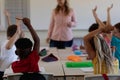 Schoolboy raising their hands in an elementary school classroom