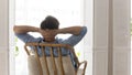 Rear view dreamy calm young man relaxing on cozy chair