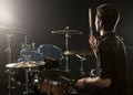 Rear View Of Drummer Playing Drum Kit In Studio