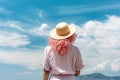 Rear view of enjoying woman by sea shore. Unrecognizable pink haired lady in straw hat portrait. Ai generative